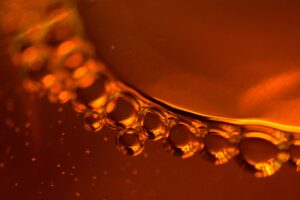 Detailed abstract close-up of bubbles in a vibrant amber liquid, creating a mesmerizing pattern.